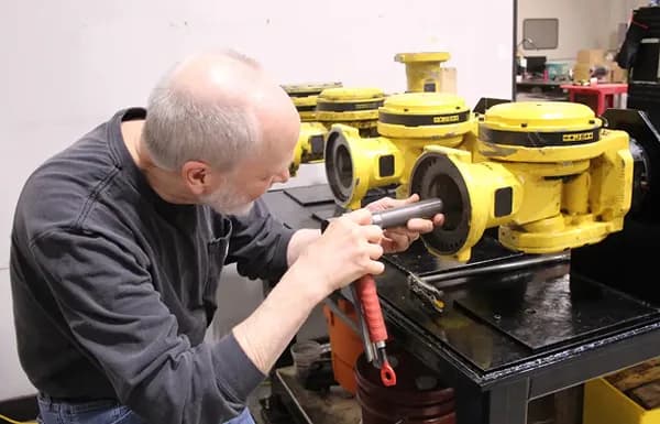 Technician inspecting disassembled Fanuc robot wrist units